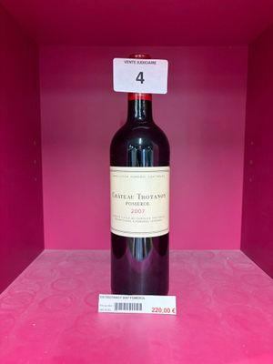 une bouteille de vin posée sur une étagère, dans une boîte rose