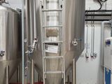 une grande cuve métallique avec une échelle au milieu