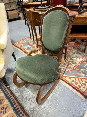 une chaise verte posée sur un tapis dans une pièce