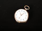une image représentant une montre de poche posée sur une surface noire