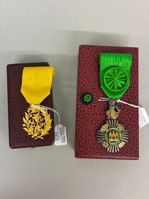 une petite boîte sur laquelle est posée une médaille et une petite boîte sur laquelle est posée une médaille