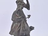 bronze statue of a woman with a dog on a white background