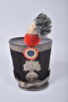 a small hat with a pom pom on top of it