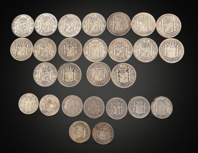 a group of silver coins on a black background