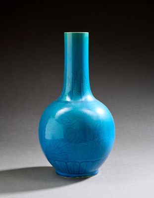 un vase en verre bleu posé sur une table, sur une surface grise