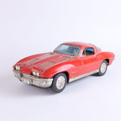 a red toy car that is sitting on a white surface