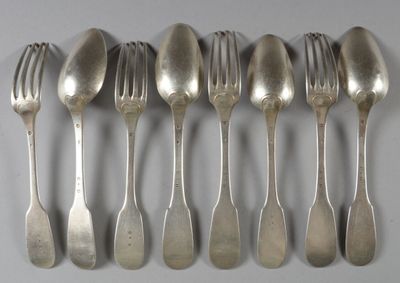 six cuillères et six fourchettes alignées sur une table