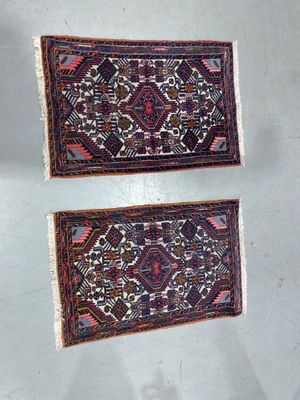 two small rugs hanging on a wall in a room