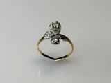 a close up of a gold and white diamond ring on a white surface