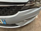 the front end of a silver car with a number plate on it