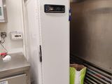 un réfrigérateur blanc dans une cuisine, avec une affiche bleue sur la porte