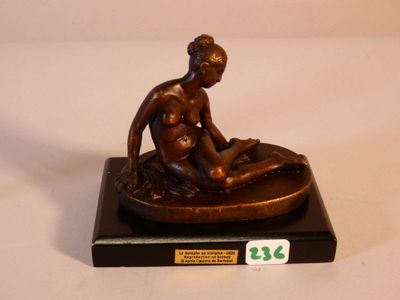 statue représentant une femme assise sur les genoux d'un homme, posée sur un socle en marbre