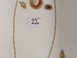 un collier en or orné d'une pierre rouge