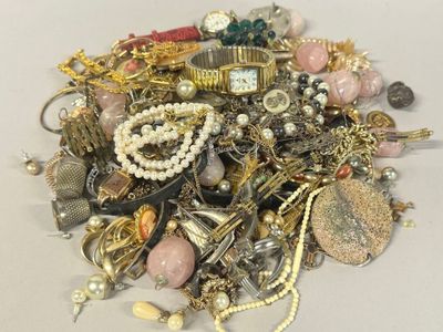 a pile of assorted jewelry on a white surface