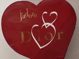 une boîte rouge en forme de cœur sur laquelle est inscrit le mot « Dior »