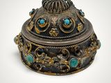 a close up of a metal box with a turquoise stone in it