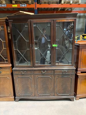 un vaisselier en bois avec des portes vitrées dans un magasin