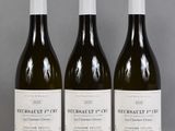 trois bouteilles de vin sont alignées sur une table