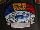 embroidered patches on a black jacket with a picture of a man swimming in a tub