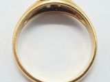 a close up of a gold ring with a diamond in the center