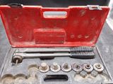 un jeu d'outils dans un coffret rouge posé sur une table