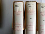 trois livres sont alignés sur une étagère devant une fenêtre