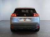 the rear end of a silver car in a white room