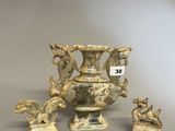 trois vases et statues anciens posés sur un socle gris