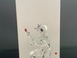 une figurine en verre posée sur une table, à côté d'une carte