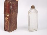 a small glass bottle next to a small glass bottle