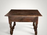an old wooden table with turned legs on a white background