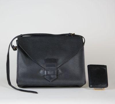 une photo d'un sac à main noir avec un téléphone portable à côté