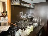 a bar with a lot of wine glasses and plates on it