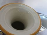 a close up of a vase with a handle on a table