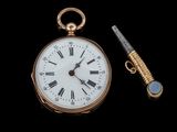 une montre de poche et un stylo sur fond noir