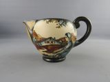 a small cup with a painting on it sitting on a table