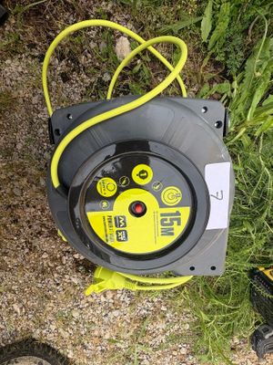 a yellow and black hose on the ground next to a pair of shoes