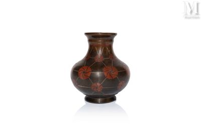 a brown vase with red flowers on it on a white surface