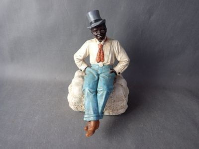 a figurine of a man sitting on a rock