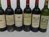 six bottles of wine are lined up on a table