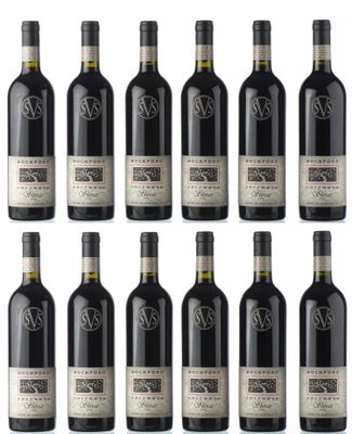 six bouteilles de vin rouge sont alignées sur une surface blanche