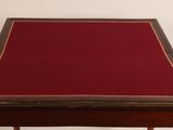 an old wooden table with a red cloth on top of it