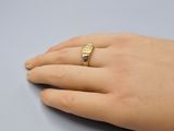 a woman ' s hand with a gold ring on it