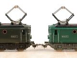 two toy trains sitting side by side on a wooden table