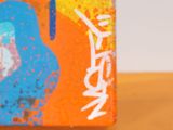 a small box with a painting on it sitting on a table
