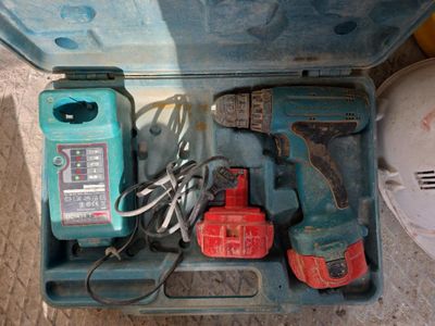 une boîte à outils bleue avec des outils sur le sol