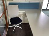 a white desk with a black chair in an office