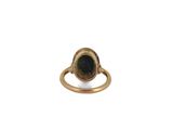 a close up of a gold ring with a black stone