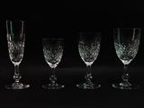 four wine glasses are lined up in a row on a black background