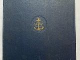 an old navy book sitting on top of a white table